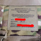 Label on a camouflage improved outer tactical vest with text details.