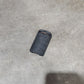 Several black cylindrical textured grip or sleeve components scattered on a concrete floor, with a cardboard box edge visible at the left.