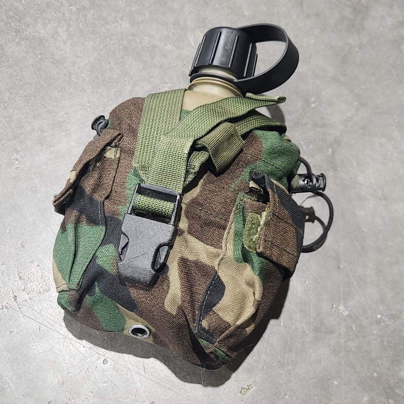 Camouflage-patterned pouch on a concrete surface