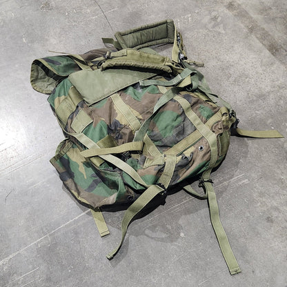 Camouflage backpack on a gray tiled floor