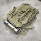 Green tactical backpack on a concrete floor
