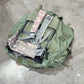 Green military-style backpack on a concrete floor