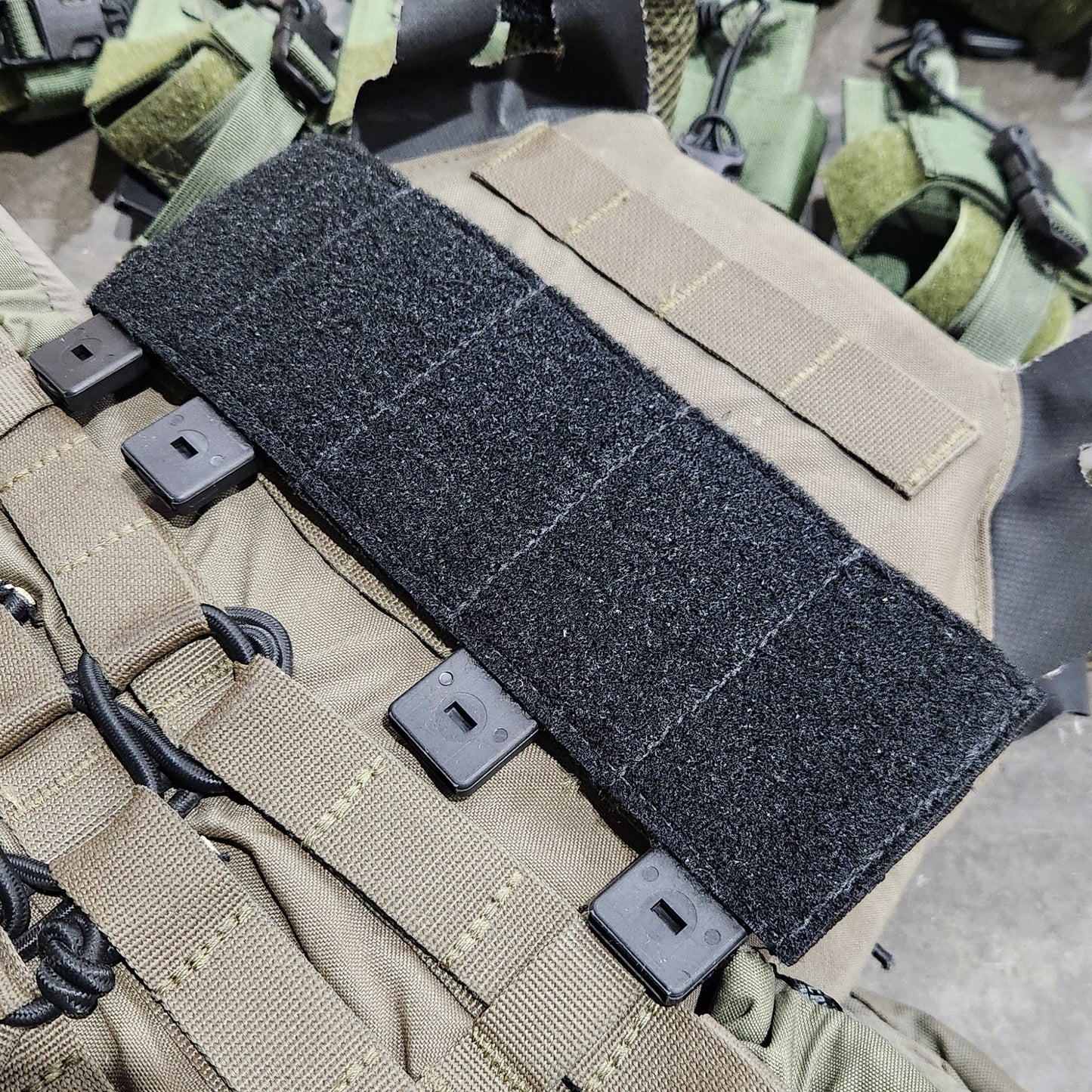 Close-up of tactical gear with a strap and buckle on a textured surface