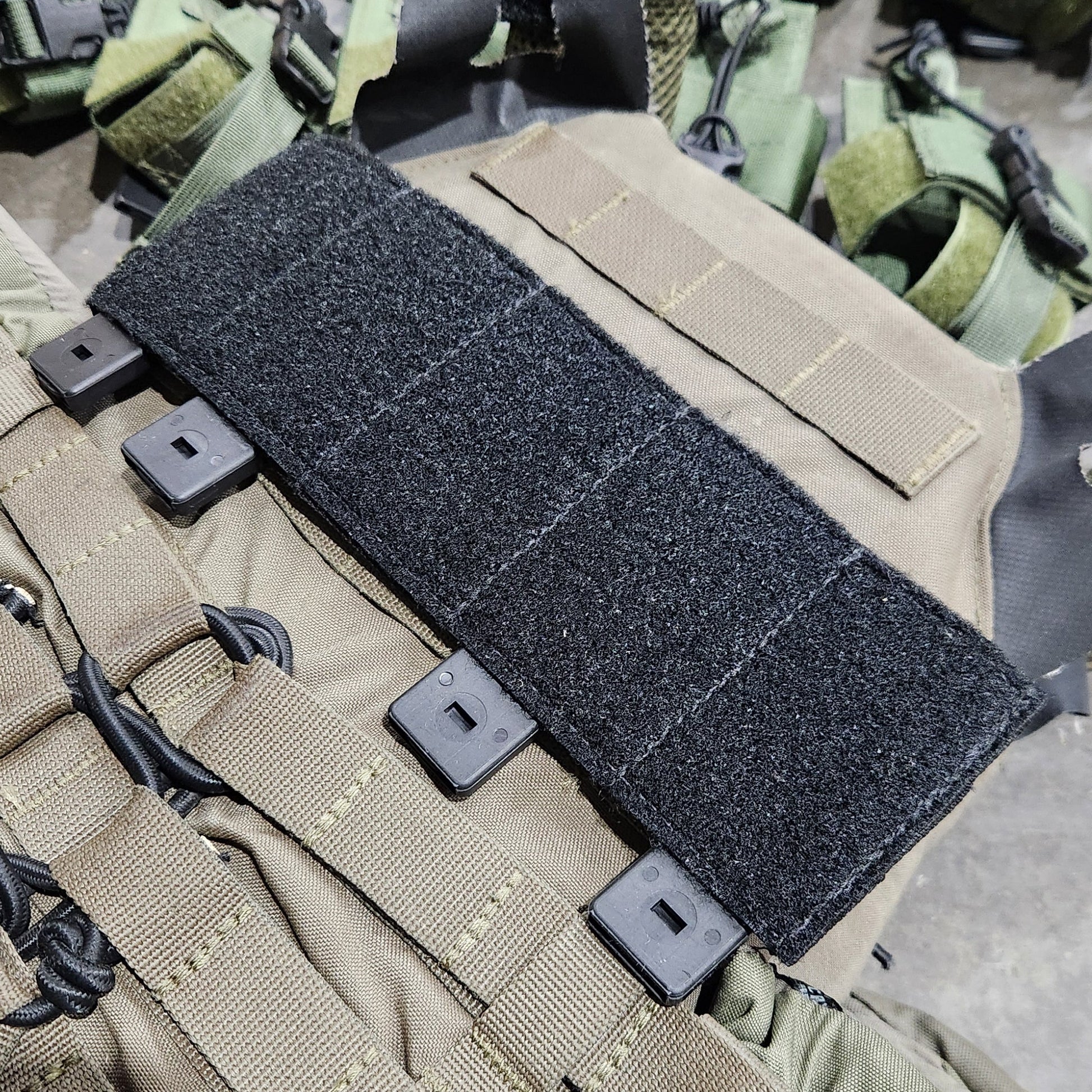 Close-up of tactical gear with a strap and buckle on a textured surface