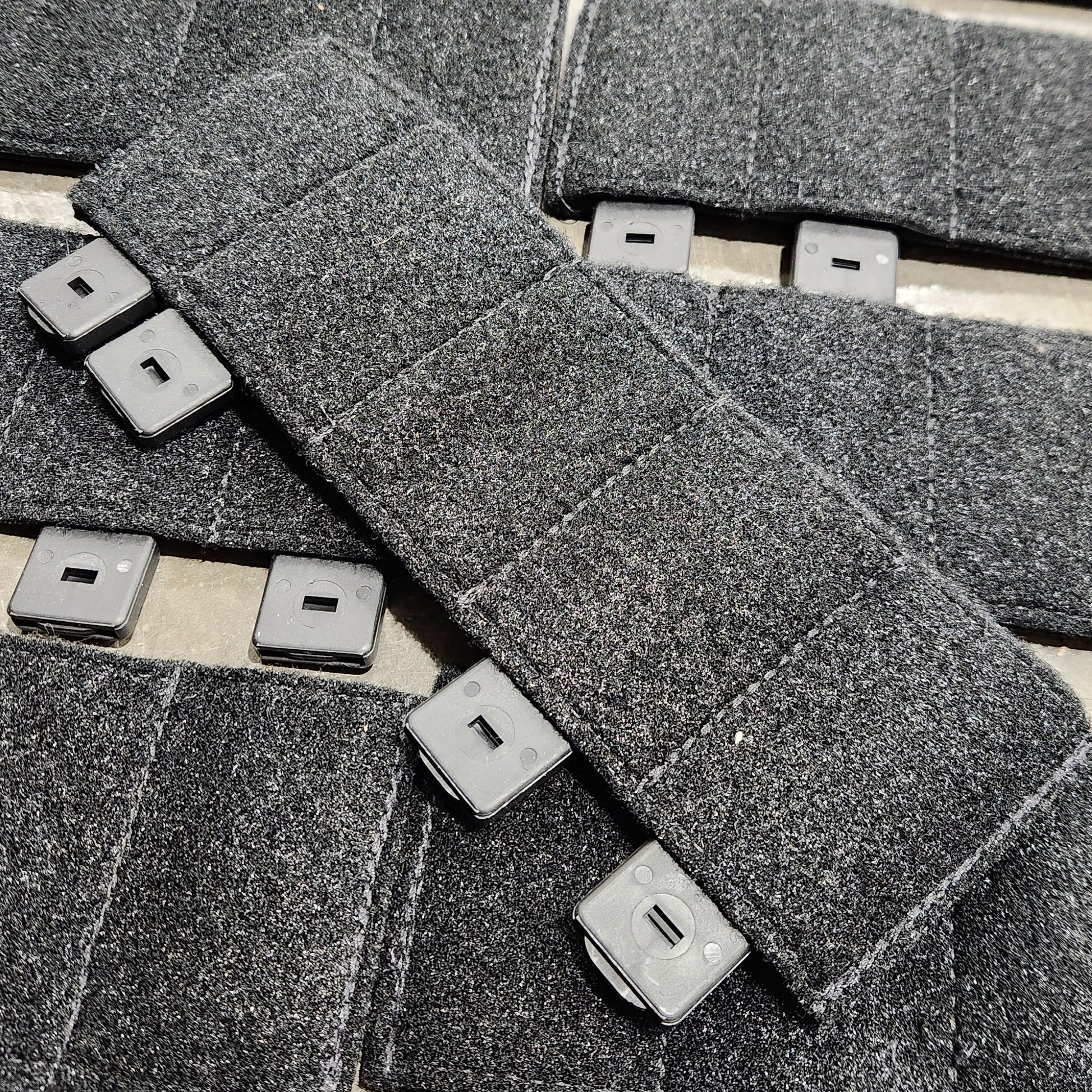 Close-up of textured gray tiles with square cutouts on a light background