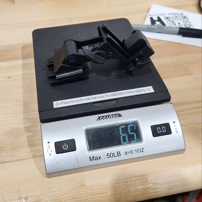 A digital kitchen scale with a silver body and black platform, displaying 6.5 lbs on a light wood tabletop.