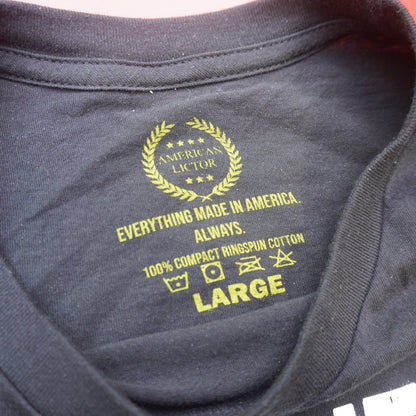 Dark gray hoodie with yellow text and logo on a red surface