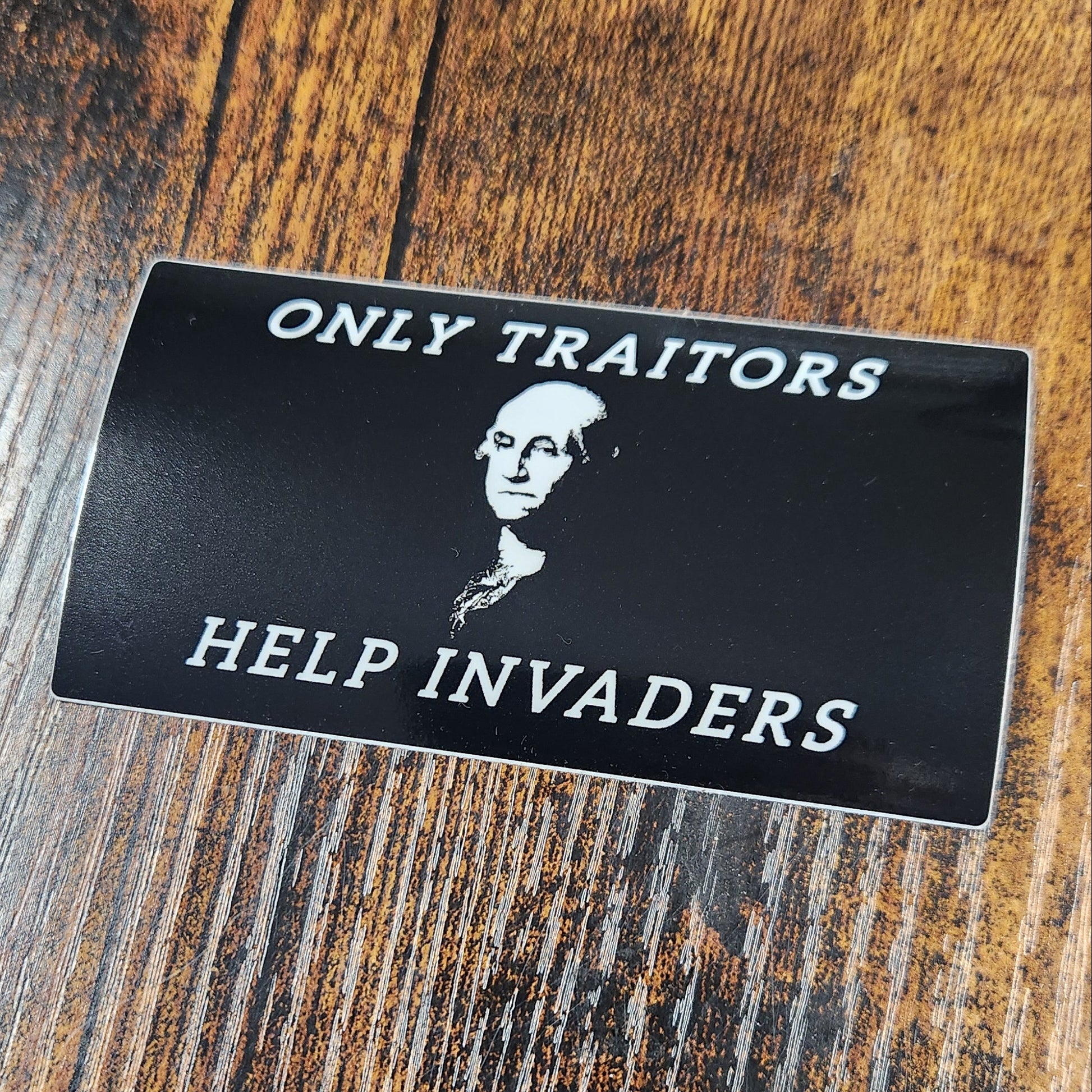 Black card with text and a portrait on a wooden surface