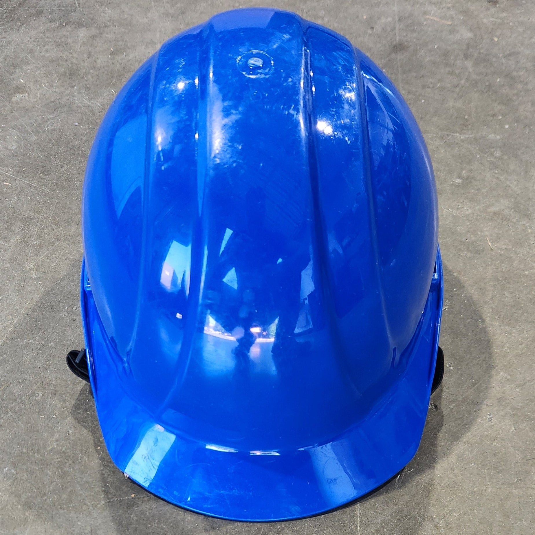 Blue hard hat on a concrete floor