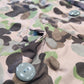 Close-up of a camouflage jacket with a button