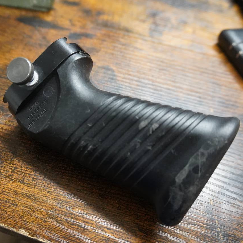 Black gun grip on a wooden surface