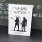 A white rectangular product package with black text reading 'PRIMAL WIPES' and a black graphic, placed on top of an olive green metal storage box against a dark gray surface.