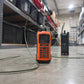 Orange handheld device with a cable on a warehouse floor
