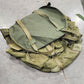 Two green military-style duffel bags on a concrete floor.