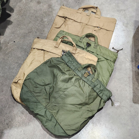 Two green and beige bags on a concrete floor