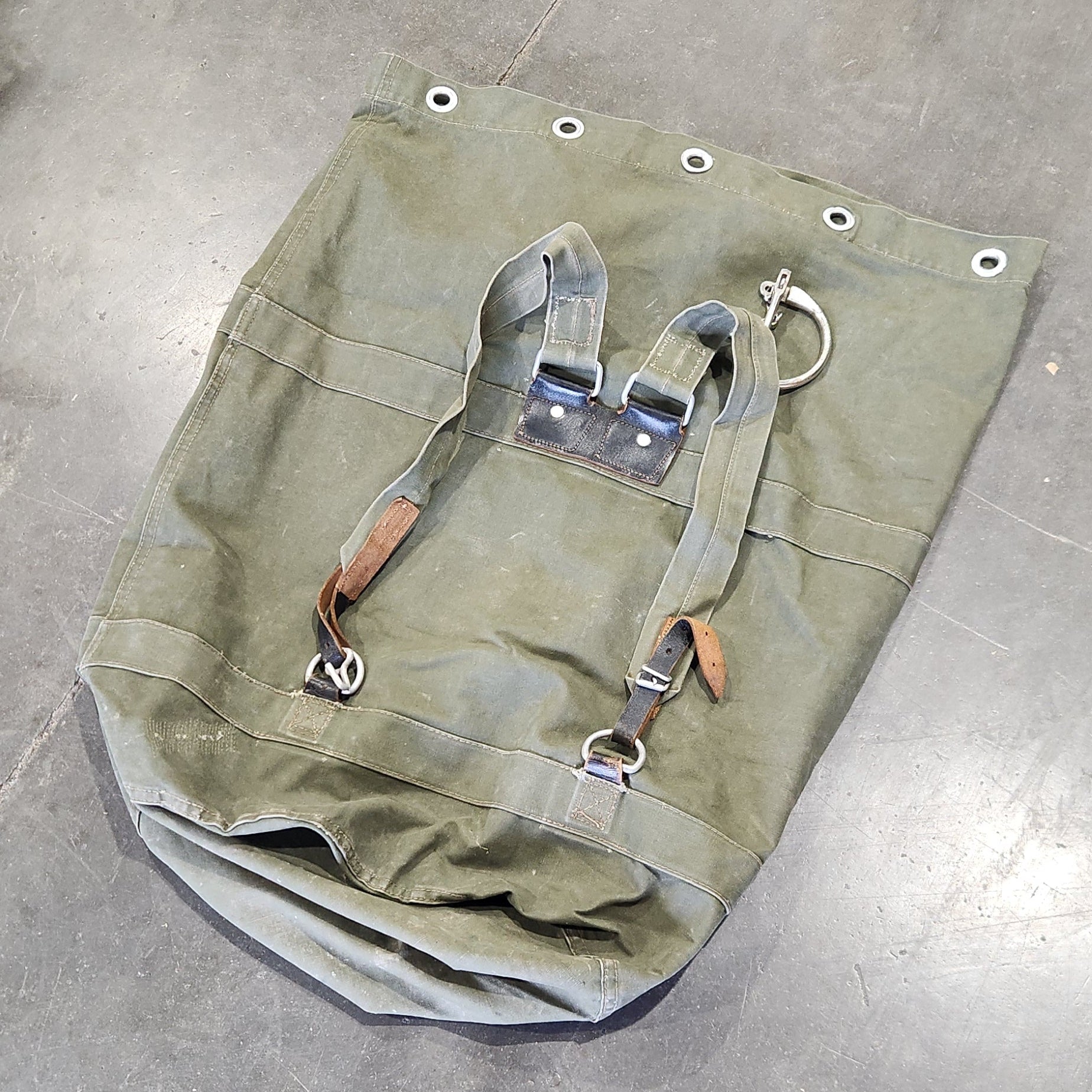 Green bag with straps on a gray concrete floor