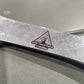 Close-up of a car door with a warning triangle symbol on a metallic surface.