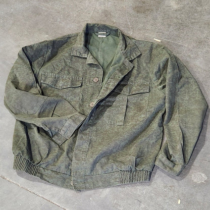Worn green jacket on a concrete floor