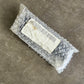 Small package wrapped in bubble wrap on a concrete surface