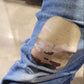 Bandage on a knee with a visible brand logo, worn on blue jeans.