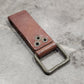 Brown leather bottle opener on a gray concrete surface