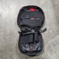 Black travel bag with red accents on a gray concrete surface