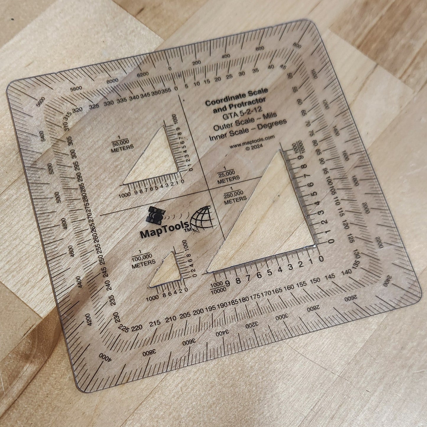 Square ruler with measurements on a wooden surface
