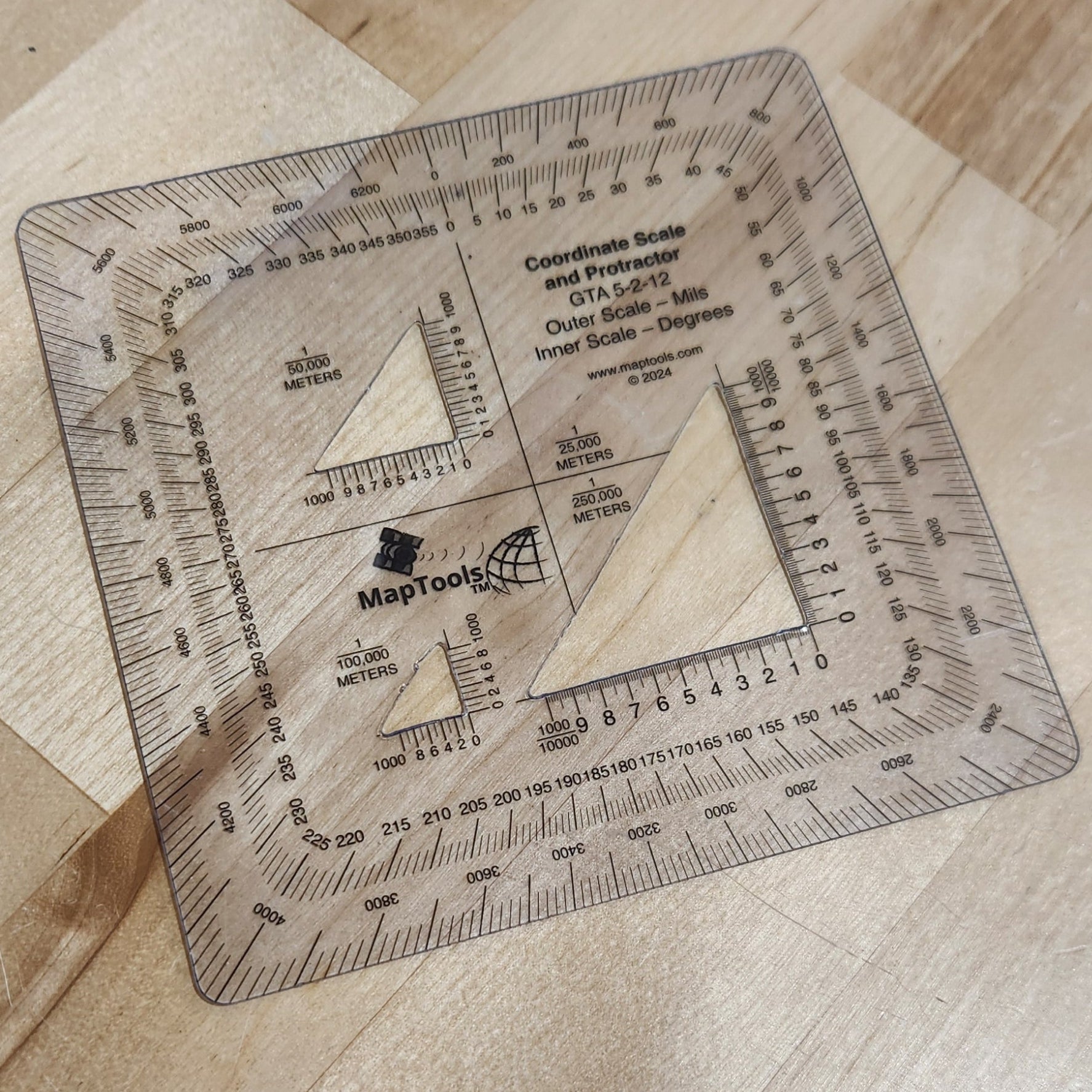 Square ruler with measurements on a wooden surface