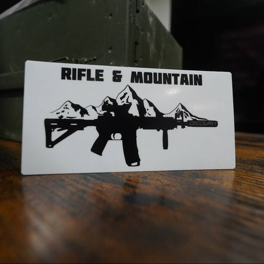 Card with 'Rifle & Mountain' logo on a wooden surface