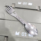 Metallic spoon and fork set on a gray background