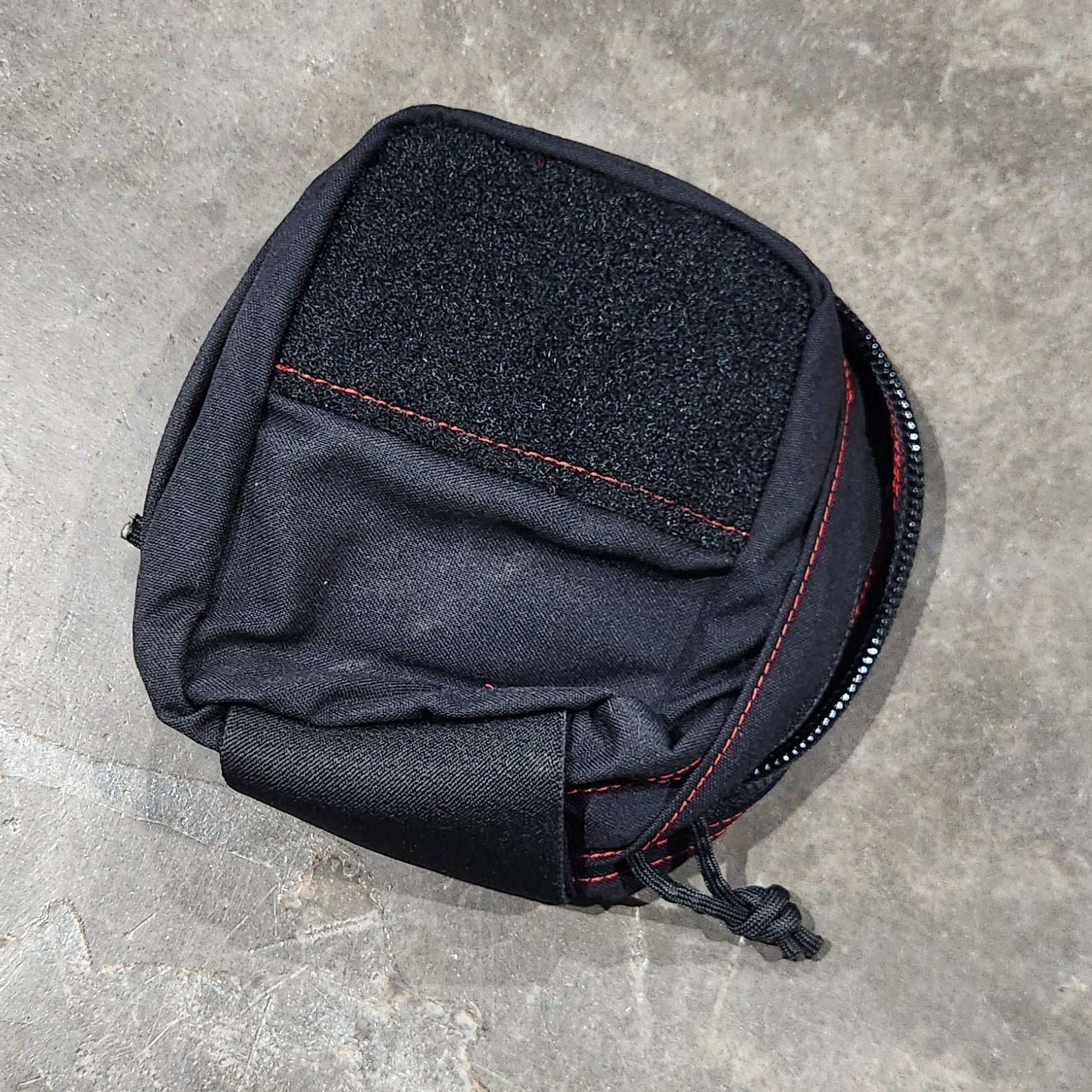 Black pouch on a gray concrete surface