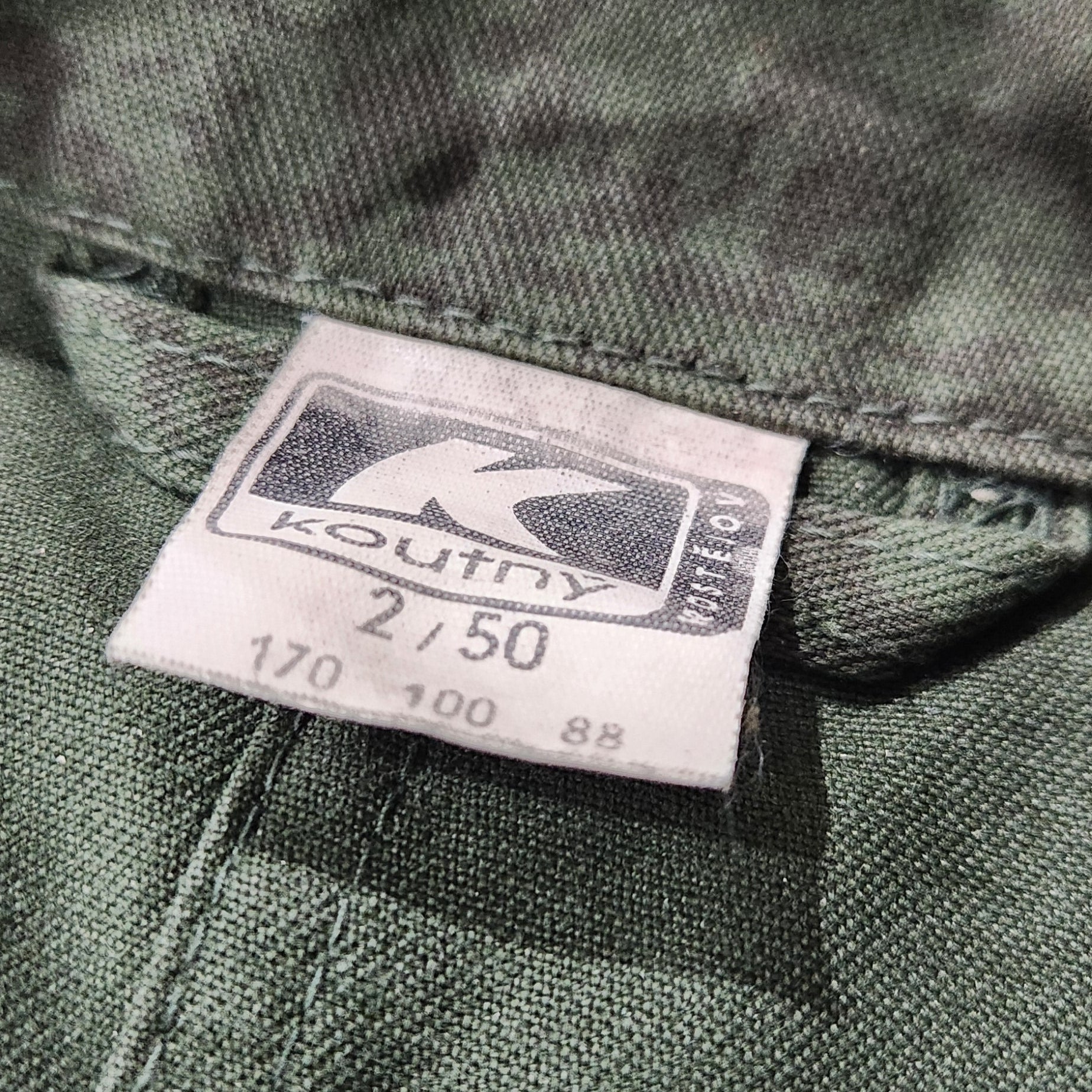 Close-up of a clothing tag on a green fabric background