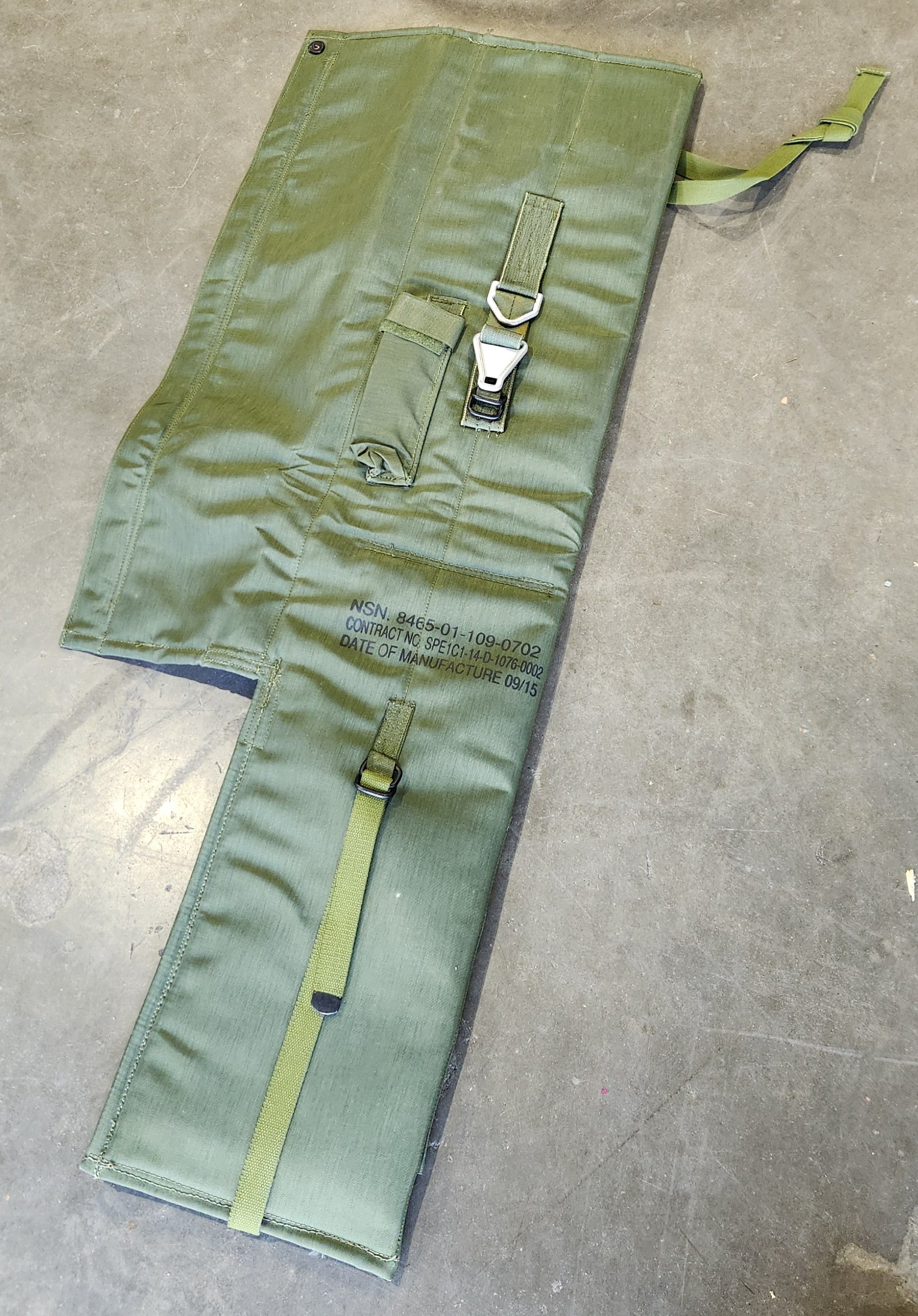 Green tool roll with a strap on a concrete floor