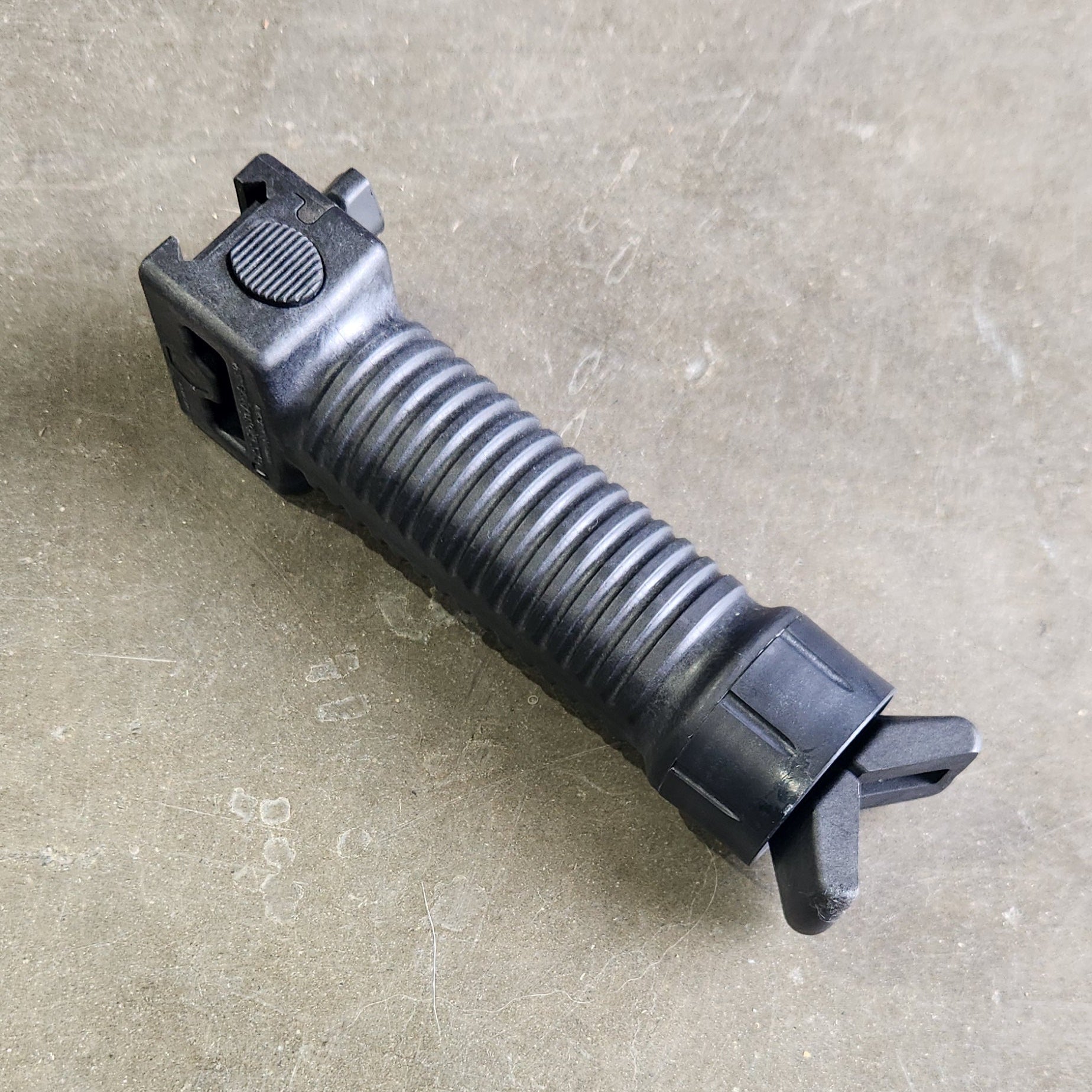 Black tactical grip on a concrete surface