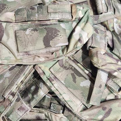 Stack of camouflage pouches on a dark background