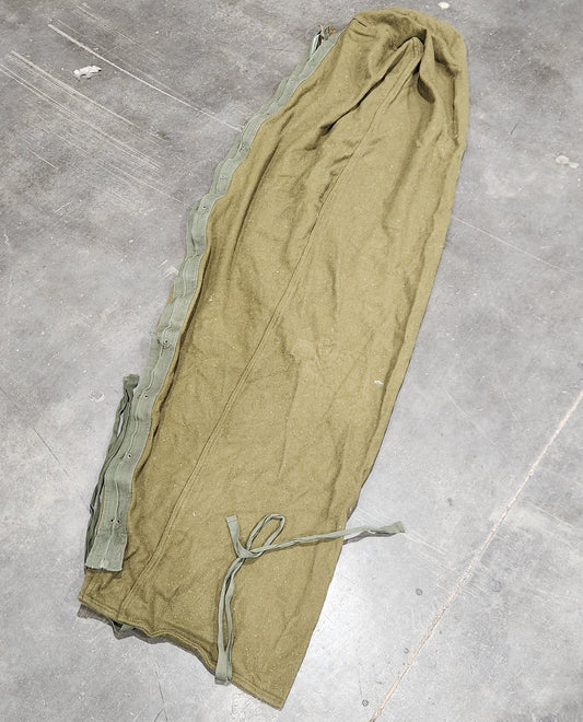 Green fabric on a gray floor with a person partially visible.