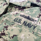 Close-up of U.S. Navy camouflage uniform with 'U.S. Navy' text on a gray background