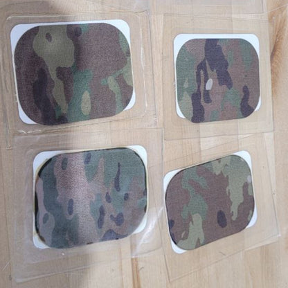 Camouflage-patterned square stickers on a wooden surface