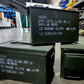 Green ammunition boxes with labels on a warehouse floor.