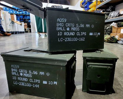 Green ammunition boxes with labels on a warehouse floor.