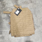 Tan tactical pouch on a concrete floor with a person's foot in the background