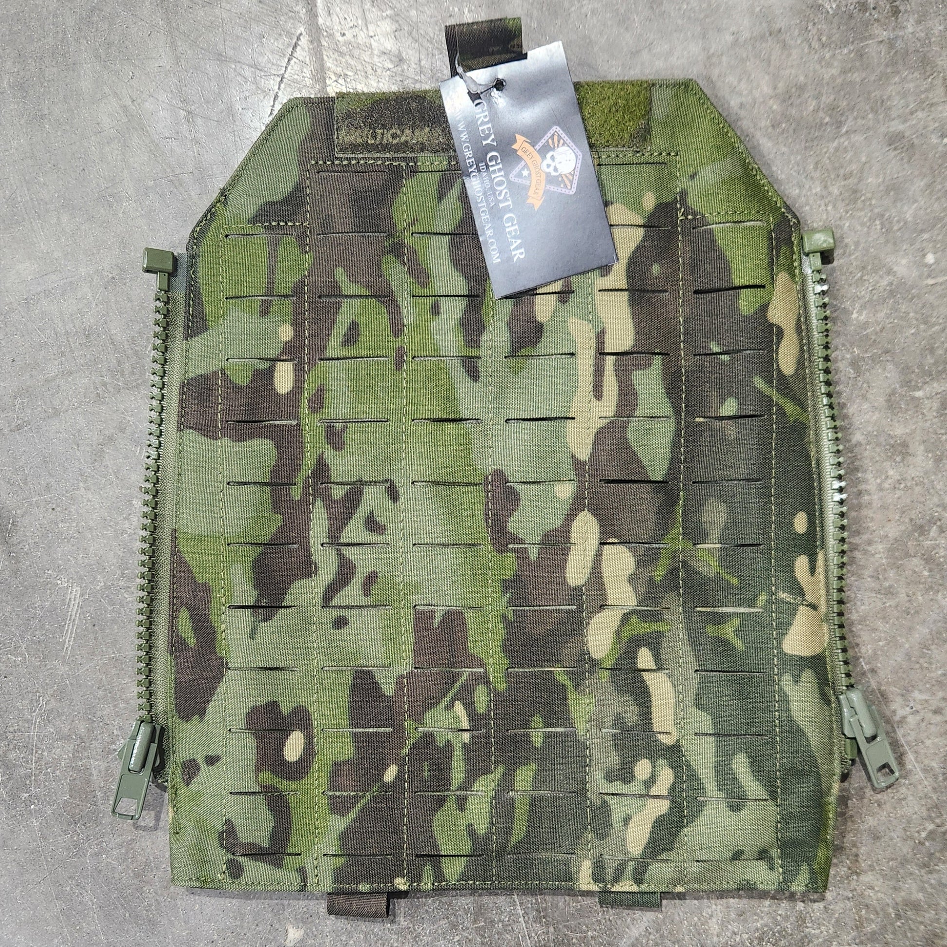 Camouflage pouch on a concrete surface with a visible brand tag.