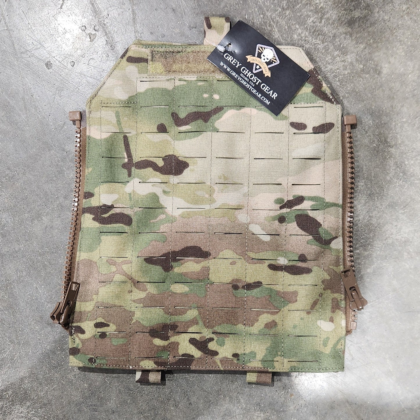 Multicam-patterned tactical plate carrier on a concrete floor