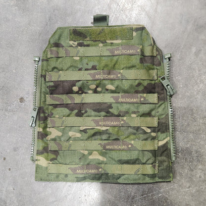 Camouflage-patterned tactical vest on a concrete floor