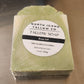 Green soap bar with a label on a reflective surface