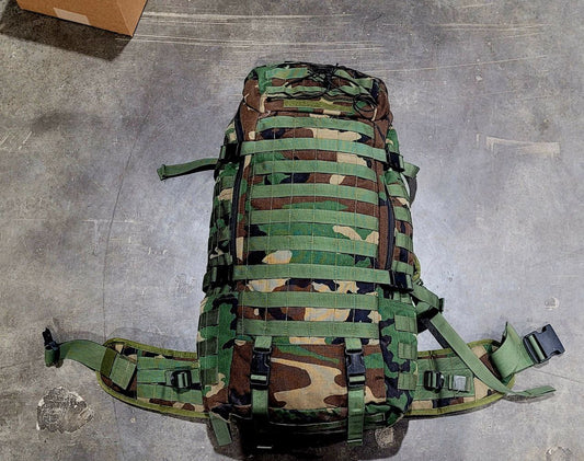 Camouflage backpack on a concrete floor
