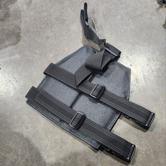 Black tactical pouch with straps on a concrete floor