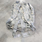 Camouflage backpack on a concrete floor
