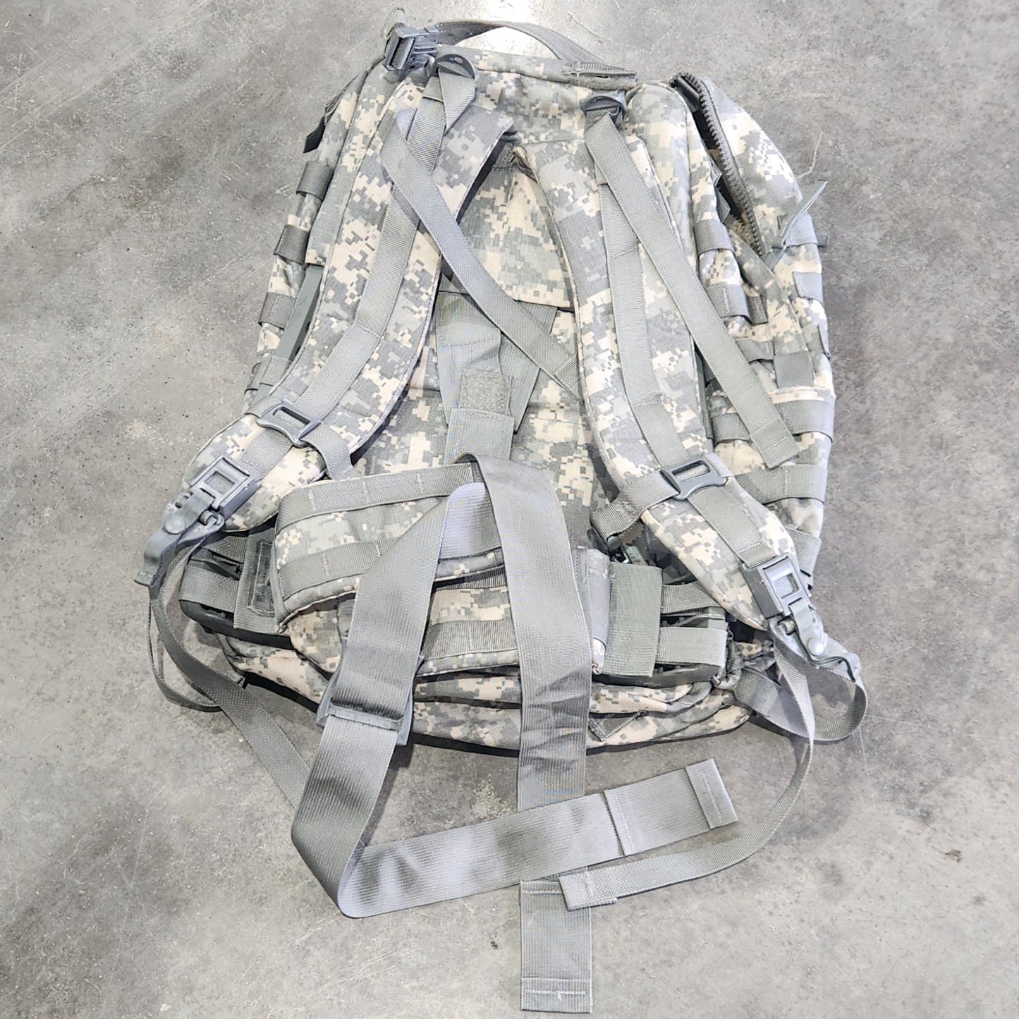Camouflage backpack on a concrete floor