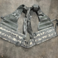US Military load bearing vest displayed on mannequin, tan in color with multiple pouches and straps.